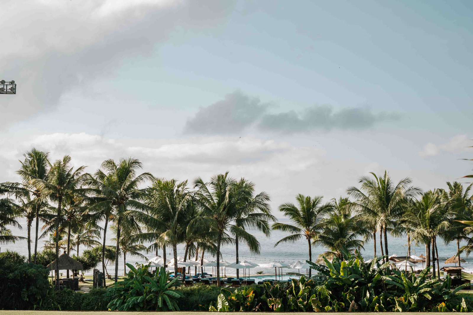 KOMUNE_IMG2-13 A serene bathroom interior featuring a modern white bathtub next to large glass windows overlooking a lush green forest with a hanging chair and wooden deck.