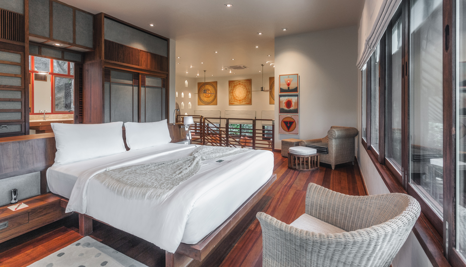 Kamalaya Koh Samui_Villa Garden View An infinity pool overlooking a serene tropical coastline, surrounded by lush trees and greenery with a stunning ocean and distant islands in the background. The pool area features comfortable loungers and an elegant open-air design.