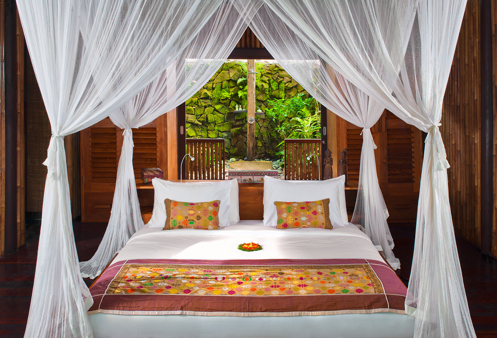 Two Bedroom Bidadari Riverfront Suite with Private Pool 05 A practitioner performs cupping therapy, holding a flame to prepare glass cups for placement on a patient's back. The scene is set near a window with a view of the outside.