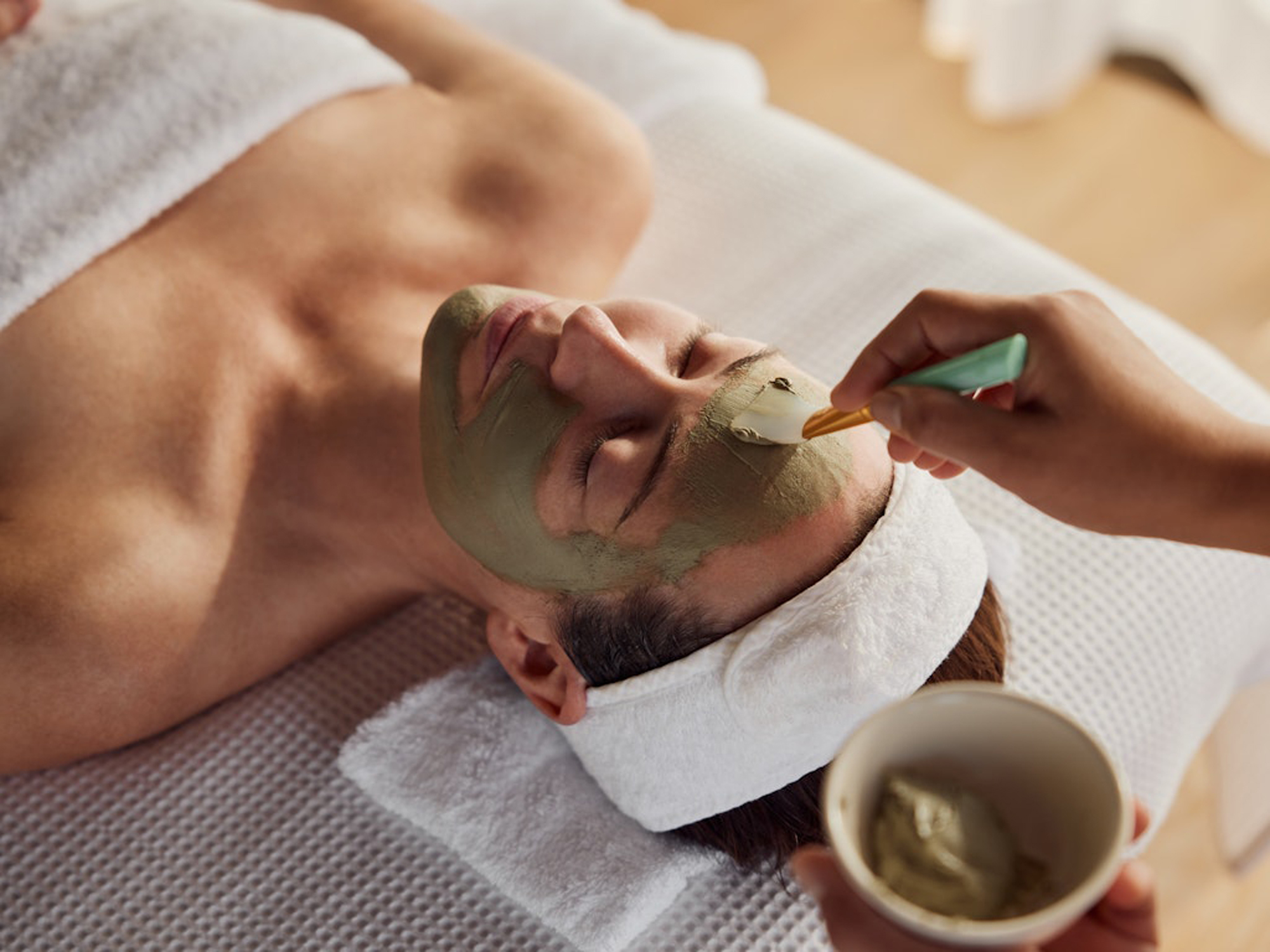 A serene spa scene with a client receiving a professional manicure from a spa technician, with soft lighting and neutral color tones.